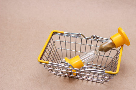 An hourglass in the shopping basket. The concept of time.