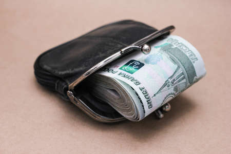 A bundle of Russian banknotes of 1000 rubles in an old black walletの写真素材