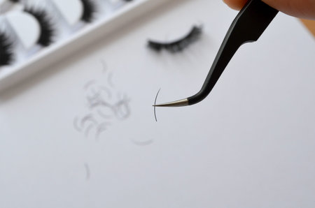 Eyelash technician one cilium, tweezers and artificial eyelashes