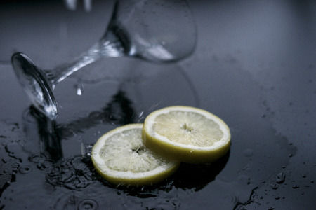 Two lemon slices with glass and waterの写真素材