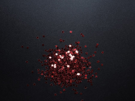 Red glittering and shiny stars at black backgroundの写真素材