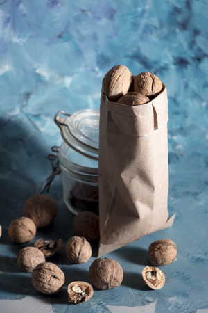 Walnuts in craft bag, nuts at blue backgroundの写真素材