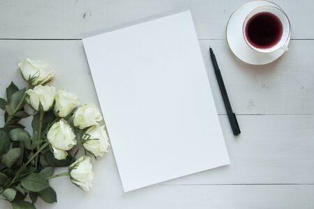 Romantic mood mock up for your text and design, top view, flat lay, album sheet with white rose and pen at rustic wooden background. Blank greeting card or illustration sheet, copy past.の写真素材