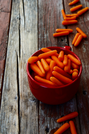 Baby cut carrots on rustic wooden background. Selective focus.の写真素材