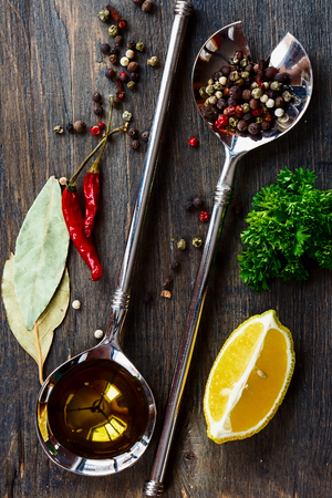Top view of Vintage Spoon with Olive Oil and spices over wooden backgroundの写真素材