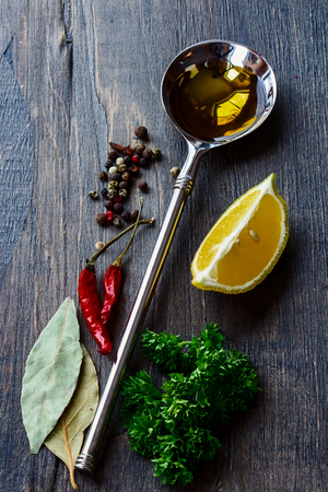 Vintage Spoon with Olive Oil and spices on wooden textureの写真素材