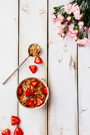 Top view of cereal and strawberry on white wooden backgroundの写真素材