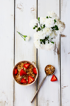 Healthy breakfast with cereal and strawberry on white wooden background. Top view.の写真素材