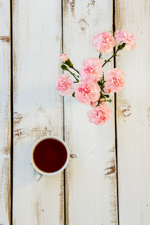 Tea and flowers on white wooden background. Tea ceremony concept. Top view.の写真素材