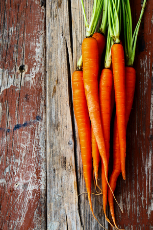 Top view of Fresh Carrots bunch on grungy wooden background.の写真素材