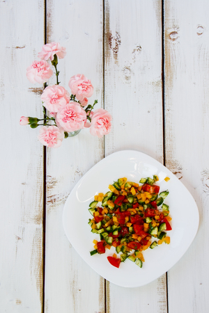 Fresh healthy vegetables salad on white wooden background. Top viewの写真素材