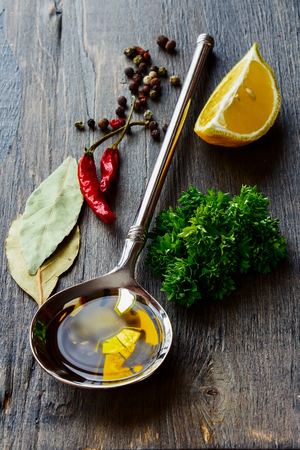 Vintage Spoon with Olive Oil and spices over wooden backgroundの写真素材