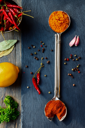 Bright spices over wooden and slate background. Cooking or spicy food concept. Top view.の写真素材