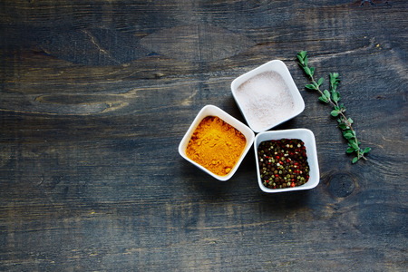 Colourful dried spices in bowls over rustic wooden background. Top view.の写真素材