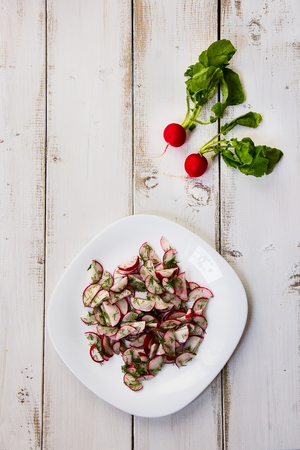 Spring salad with radishes and dill on white wooden background. Top view.の写真素材
