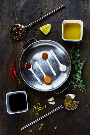 Herbs and spices selection on dark wooden board. Food and cuisine ingredients. Top view.の写真素材