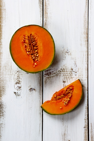 Cantaloupe melon on white wooden background. Top viewの写真素材