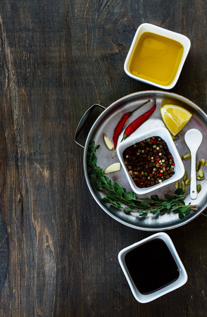 Various kind of herbs and spices selection on dark wooden board. Food and cuisine ingredients. Top view.の写真素材