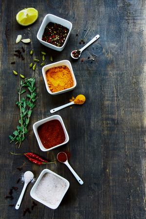 Spices and herbs selection with copyspace over rustic wooden board. Top view.の写真素材
