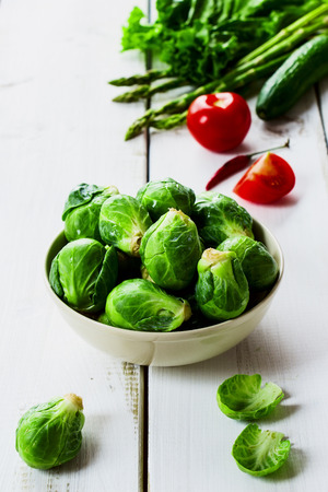 Fresh green brussel sprouts and Healthy Organic Vegetables on White Wooden Backgroundの写真素材