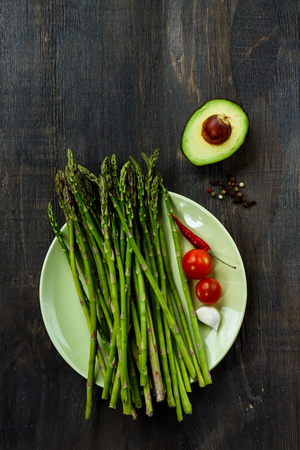 Avocado and ingredients on dark wooden background. Vegetarian food, health or cooking concept. Top view.の写真素材