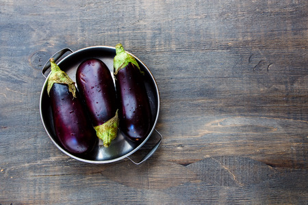 Fresh eggplants on dark wooden background.. Vegetarian food, health or cooking concept.の写真素材
