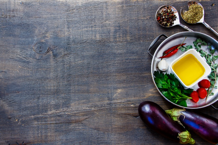 Aromatic herbs, spices and organic vegetables on a dark Wooden Background. Vegetarian food, health or cooking concept.の写真素材
