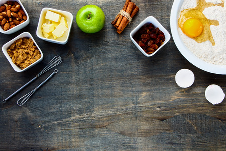 Cookies ingredients raw egg, brown sugar, apple, butter and flour over rustic wood with copyspace. Top view. Food and cuisine background.の写真素材