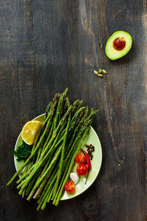 Ingredients on plate over dark wooden background. Vegetarian food, health or cooking concept. Top view.の写真素材