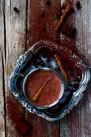 Top view of hot chocolate cocoa with cinnamon sticks on vintage wooden background.の写真素材