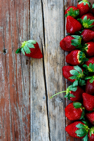 Sweet strawberries over rustic wooden background. Top view. Food Frame Backgroundの写真素材