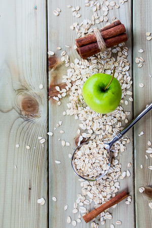 Healthy Breakfast. Oat flake, apple and cinnamon on wooden background - health and diet concept. Top view.の写真素材