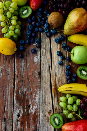 Mix of fresh juicy fruits on rustic wooden board. Healthy eating background. Top view.の写真素材