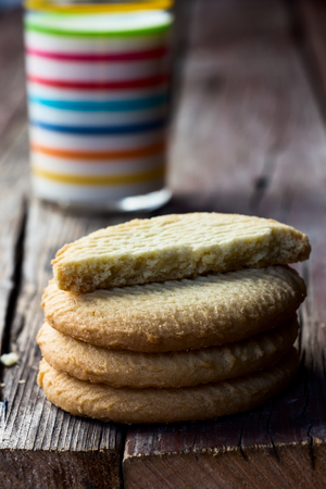 Stack of tasty cookies with milk on rustic wooden table. Selective focus.の写真素材