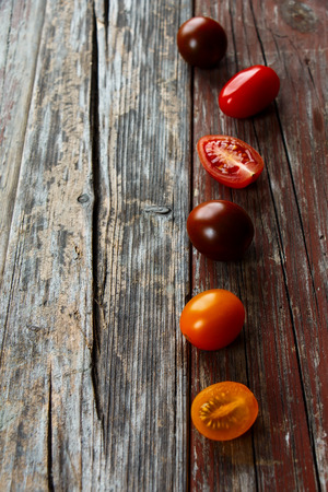 Mix of tomatoes over rustic wooden background with copy space. Selective focusの写真素材