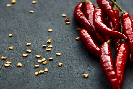 Crushed chilli flakes over dark grey background. Selective focus.の写真素材