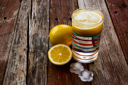 Lemonade with fresh lemon over rustic wooden background.の写真素材
