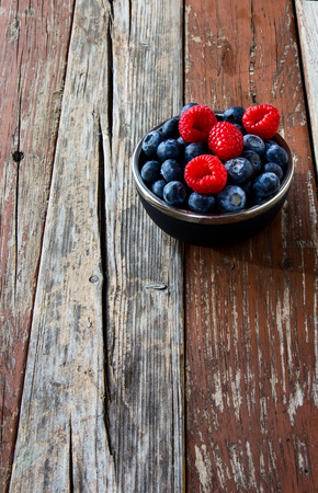 Bowl of Organic Berries on Rustic Wooden Backgroundの写真素材