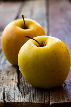 Close up of yellow apples on rustic wooden board, selective focusの写真素材