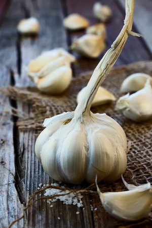 Fresh garlic on jute and wooden texture. Selective focus.の写真素材