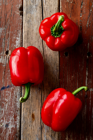 Top view of red bell peppers on old wooden planks.の写真素材