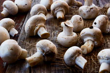 Mushrooms on jute and wooden texture. Selective focus.の写真素材