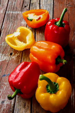 Colorful bell peppers over rustic wooden background.の写真素材