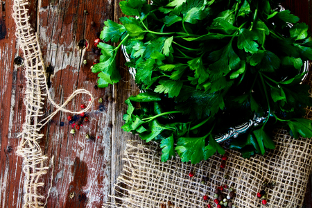 Fresh green parsley on jute and old wooden texture. Top view.の写真素材