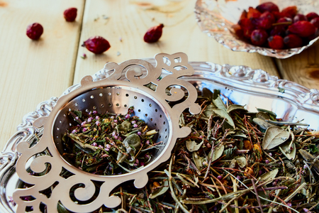 Mix of bio herbal tea and hip roses on wooden background.の写真素材