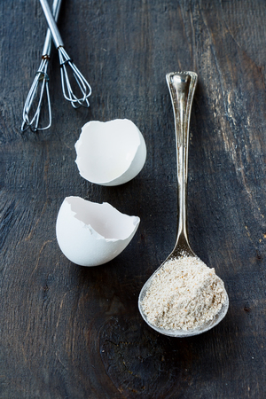 Flour on vintage spoon on dark wooden background.の写真素材