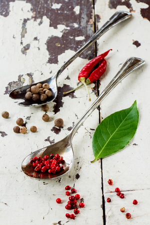 Various spices selection in vintage metal spoons over old wood texture. Selective focus.の写真素材
