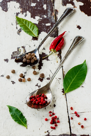 Spices selection in vintage metal spoons on old wood texture.の写真素材