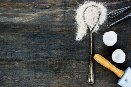 Ingredients background with copy space - flour in vintage spoon and rolling pin on wooden texture. Top view.の写真素材