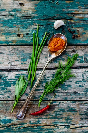 Spices in old metal spoon over wood.の写真素材